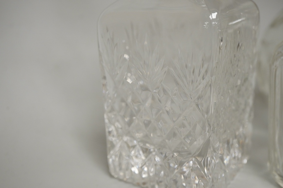 A collection of five silver mounted glass scent bottles to include one with guilloche enamel inset top, a Victorian example hallmarked for Chester 1897 and a cut glass example with mother of pearl top, London 1922, large
